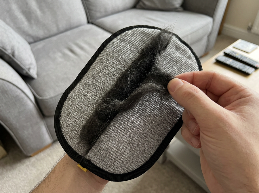 Sausage Glove lifting pet hair from a sofa