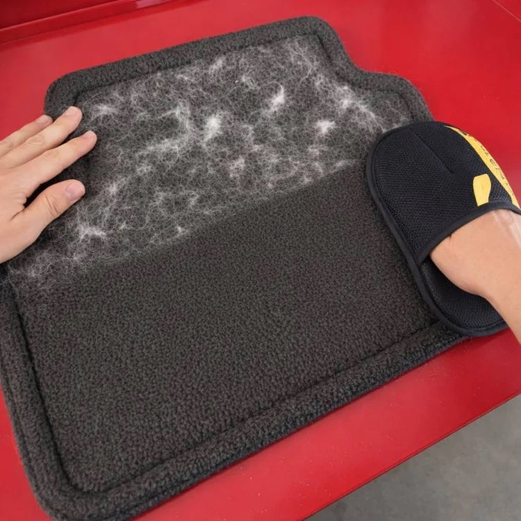 The Sausage Glove lifting pet hair from a car mat